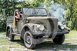 Young girl sits in military car