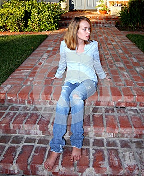 Young Girl Sits On Porch