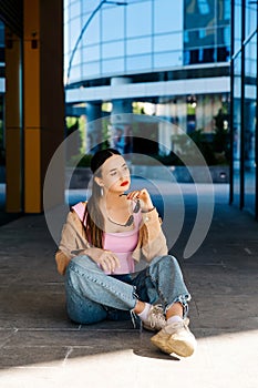 Young girl sitting on asphalt