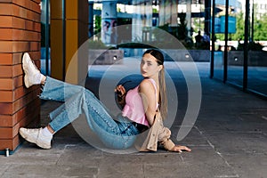 Young girl sitting on asphalt
