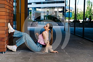 Young girl sitting on asphalt