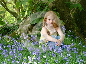 Young Girl sitting in a bluebell wood