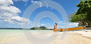 Young girl sitting on boat on beach