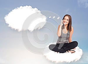 Young girl sitting on cloud and thinking of abstract speech bubble with copy space