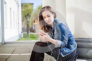 Young girl sitting on the college campus yard