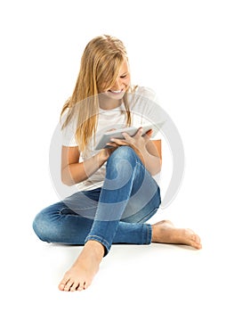 Young girl sitting on the floor using tablet pc over white background