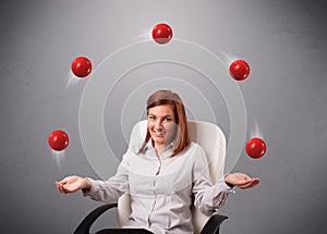 Young girl sitting and juggling with red balls