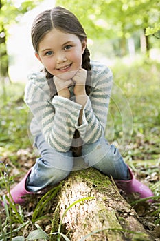 Young girl sitting on log