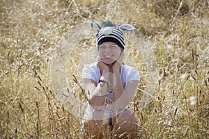 A young girl sitting in the long grass