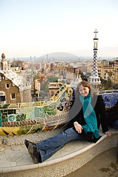 Young girl sitting on mosaic bench in Park Guell