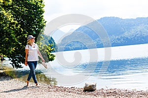 Young girl sitting near by beautiful lake . Original wallpaper from summer morning