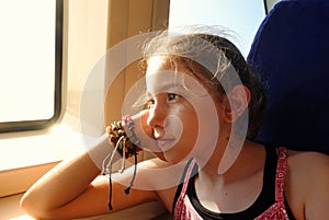 Young Girl is Sitting near the Ferry Window and Soft Sunlight Comes her face