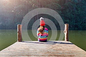 Young girl sitting on a pier