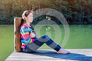 Young girl sitting on a pier.