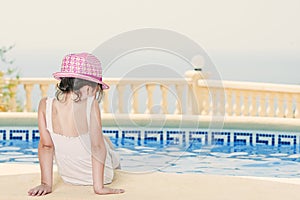 Young Girl Sitting by the Pool