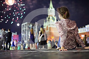 Young girl sitting on the sett on red square next