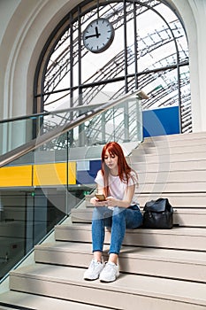 Young girl sitting on stairs of railway station