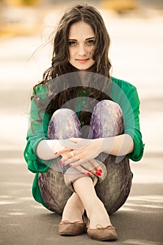 Young girl sitting on a way