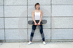 Young girl with skateboard in the city.