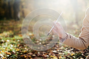 A young girl sketching near a lake in the autumn forest. Sketching. The girl is in a great mood and happy