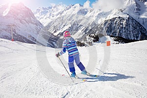 Young girl ski downhill mountain back view