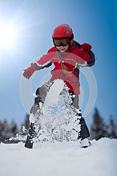 Young girl skier playing with snow