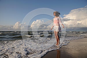 Young girl skipping on the beach