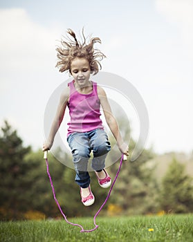 Young girl skipping in park