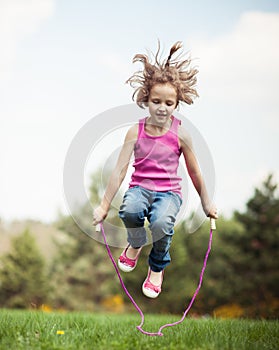 Young girl skipping in park