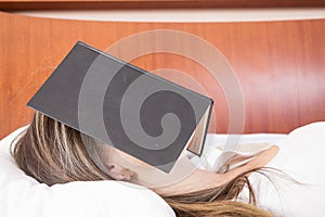 Young girl sleeping with book on her face