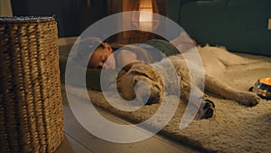 Young girl sleeping with dog on mild carpet
