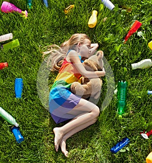 Young girl sleeping with her teddy bear in the plastic littered