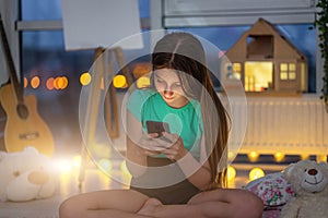 Young girl with smartphone in room