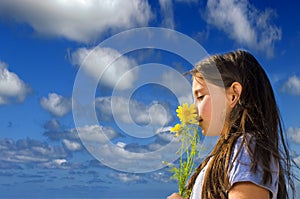 Young girl smelling flowers