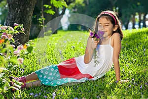 Young Girl Smelling Flowers in Her Hands.