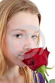 Young girl smelling a red rose