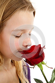 Young girl smelling a red rose