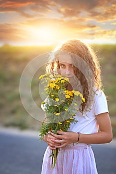 Young girl smells wildflowers