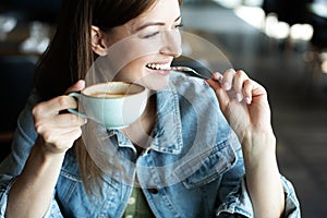 Young girl smiling and drinking delicious coffee photo