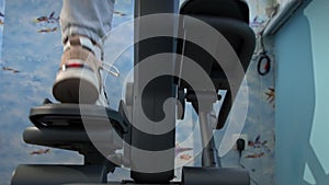 Young Girl in Sneakers is Engaged in an Orbitrek at Home, Bottom View