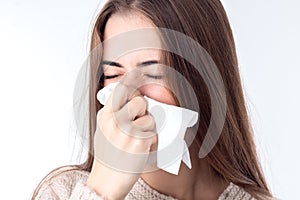 Young girl with sniffles wipes the nose closeup