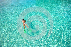 Young girl snorkeling in tropical water on