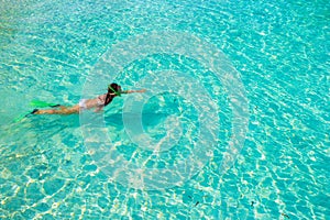 Young girl snorkeling in tropical water on