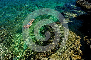 Young Girl Snorkeling through Turquoise Water at the Coast