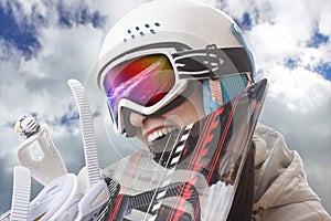 Young girl snowboarder in helmet and goggles bites snowboard