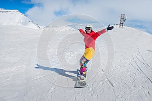 Young girl snowboarder in motion on snowboard in mountains