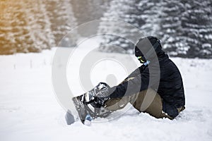 Young girl snowboarder tieing up her snowboard