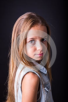 Young girl with sober look on black background