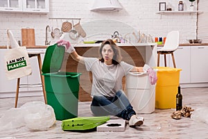 Young girl sorting garbage at the kitchen. Concept of recycling. Zero waste