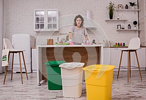 Young girl sorting garbage at the kitchen. Concept of recycling. Zero waste